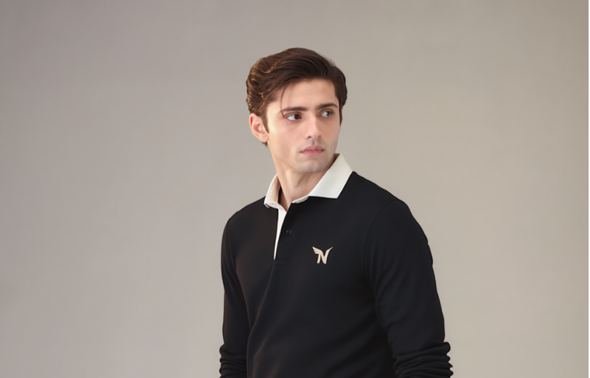 Man wearing a black sweater with a logo on a gray background